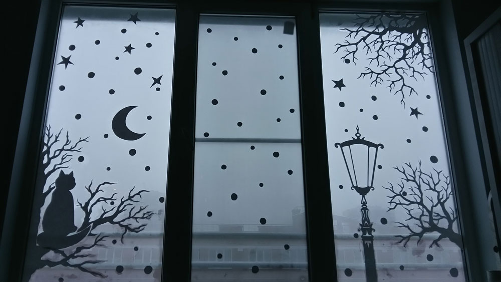 Luna și fulgi de zăpadă pe sticlă